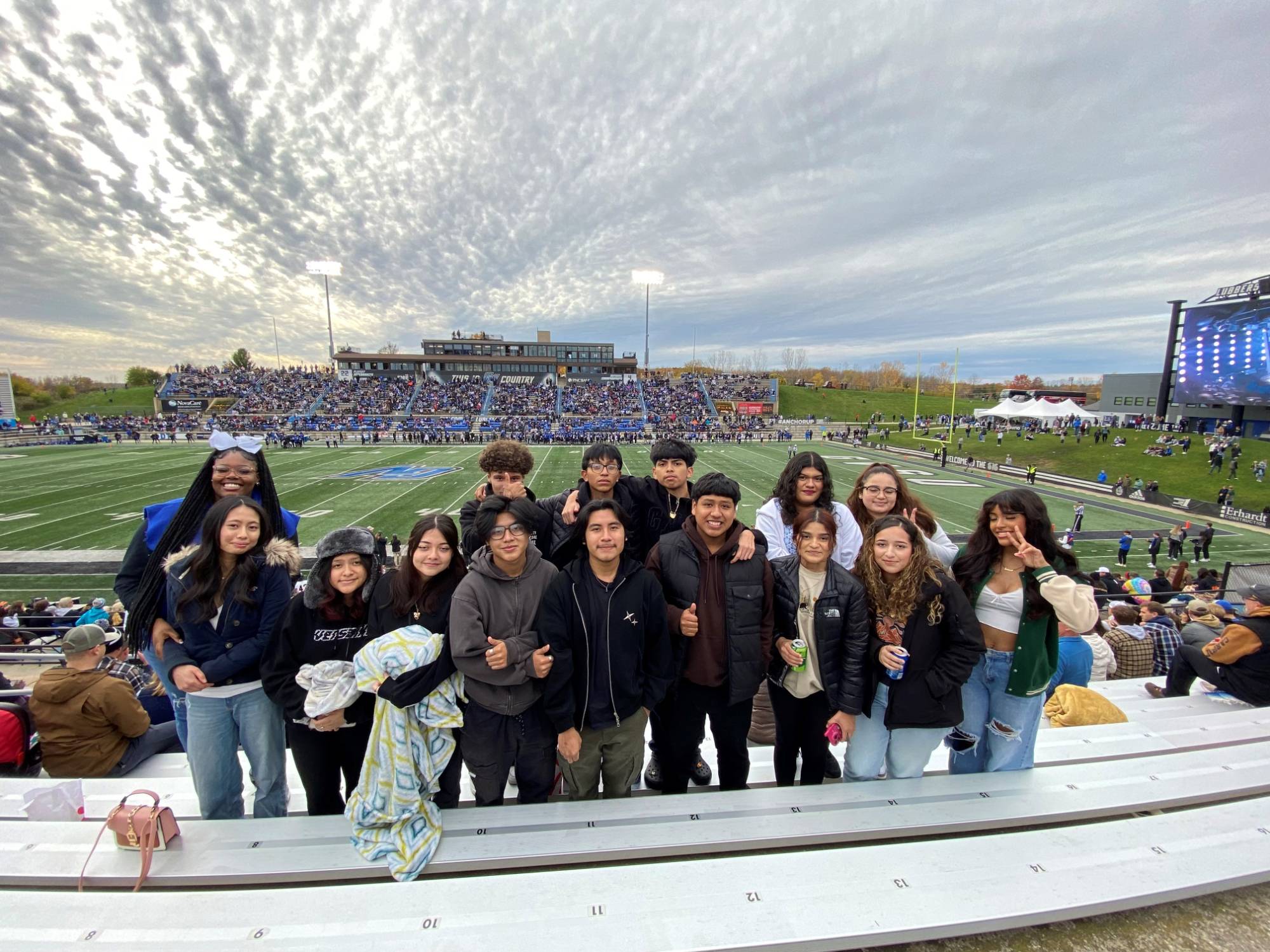 A group of students standing in the GVSU football staduim stands